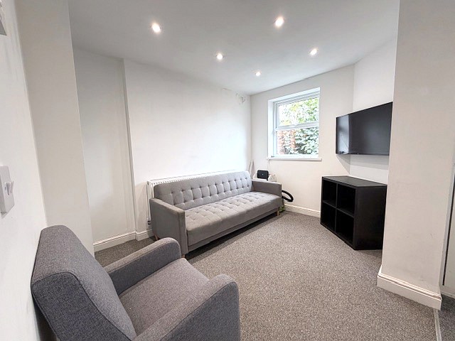 The lounge at 58 Church Street with sofa, armchair and wall-mounted TV