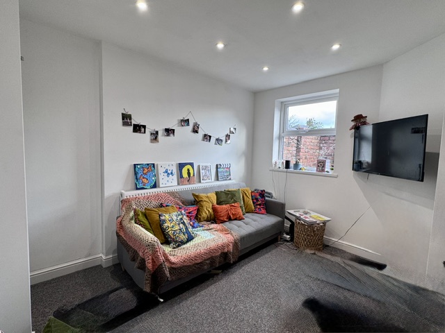 The lounge at 58 Church Street with sofa and wall-mounted TV